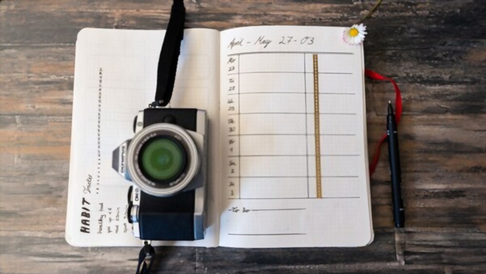 Caderno para bullet journal barato com câmera digital em cima.