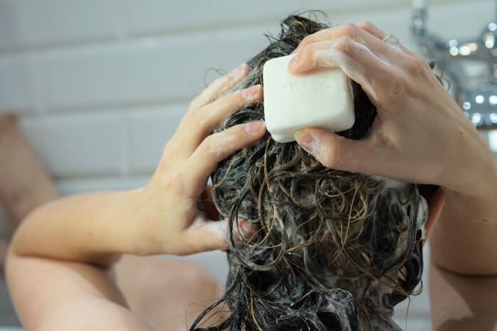 Mulher lavando o cabelo com shampoo em barra