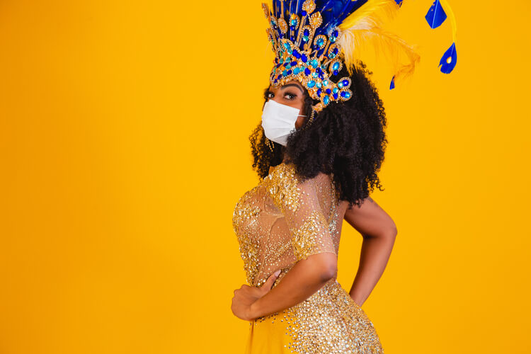 mulher usando uma fantasia de carnaval e máscara de proteção