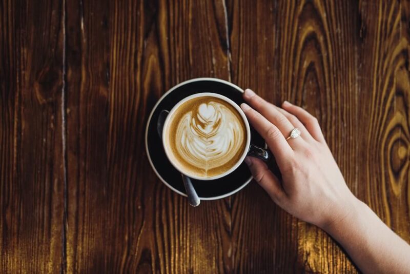 Mãos segurando xícara com café