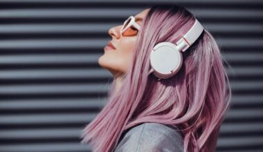 Mulher de cabelo rosa escutando música com headphones