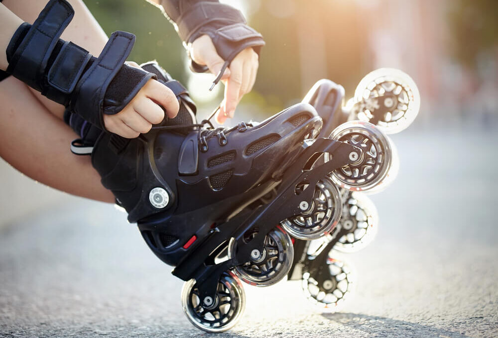 Pessoas colocando um patins inline nos pés.