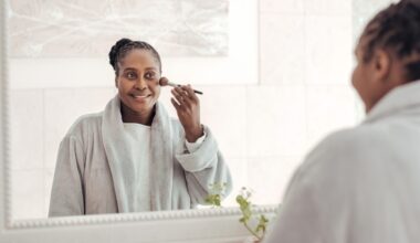 reflexo do espelho de mulher aplicando maquiagem
