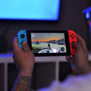 Pessoa jogando Nintendo Switch nas cores azul e vermelha.
