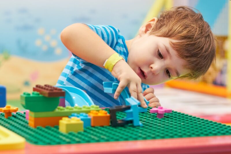 Garoto brincando de Lego.