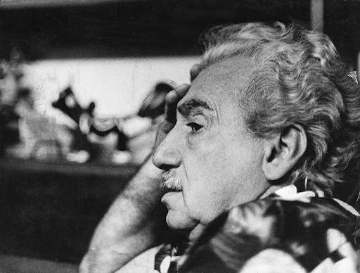 Imagem do escritor baiano Jorge Amado. Ele está de lado, com uma das mãos apoiando a cabeça. A foto é em preto e branco.