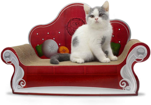 Imagem de um gato em cima de um arranhador em formato de sofá.