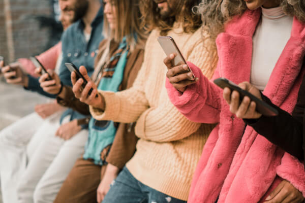 Grupo de jovens utilizando celulares de até 1500 reais
