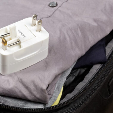 Adaptador universal de tomada acima de mala antes da viagem.