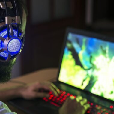 Homem com headset jogando em seu notebook gamer.